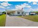 Welcoming home featuring a spacious driveway, convenient carport, and a well-kept front yard at 5745 Pawnee St, Zephyrhills, FL 33542