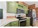 Modern kitchen featuring stainless steel appliances, green cabinets and durable countertops at 5745 Pawnee St, Zephyrhills, FL 33542