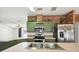 Kitchen with brick accent wall, stainless steel appliances, and green cabinets at 5745 Pawnee St, Zephyrhills, FL 33542