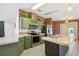 Well-equipped kitchen with green cabinets, stainless steel appliances, and a brick accent wall at 5745 Pawnee St, Zephyrhills, FL 33542