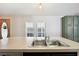 Kitchen island sink with stainless steel fixtures, window, and green cabinets at 5745 Pawnee St, Zephyrhills, FL 33542