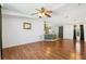 Open living area features hardwood flooring, ceiling fan and kitchen access at 5745 Pawnee St, Zephyrhills, FL 33542