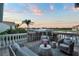 Waterfront balcony featuring comfortable seating and views of the boat harbor and blue skies at sunset at 6113 Pasadena Point Blvd, Gulfport, FL 33707