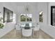 Bright dining area featuring a glass table, white chairs, elegant chandelier, and abundant natural light from the windows at 6113 Pasadena Point Blvd, Gulfport, FL 33707