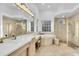 Elegant bathroom features dual sinks, a soaking tub, a glass enclosed shower, and ample vanity space at 6113 Pasadena Point Blvd, Gulfport, FL 33707