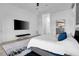 Spacious main bedroom is bright and open, featuring neutral tones, a large TV, and modern decor at 6113 Pasadena Point Blvd, Gulfport, FL 33707