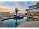 Waterfront pool with a boat dock, surrounded by tropical plants and comfortable seating at 6113 Pasadena Point Blvd, Gulfport, FL 33707