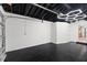 Spacious basement features painted walls, black floor and modern hexagon lighting at 6531 2Nd N Ave, St Petersburg, FL 33710