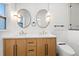 Stylish bathroom features a double sink vanity, round mirrors with pendant lights, and modern fixtures at 6531 2Nd N Ave, St Petersburg, FL 33710