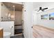 Bathroom showcasing glass shower with black fixtures, with a view into a bedroom with hardwood floors at 6531 2Nd N Ave, St Petersburg, FL 33710
