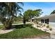 Home's front yard includes vibrant landscaping, green grass and mature shade trees at 6531 2Nd N Ave, St Petersburg, FL 33710