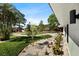 Landscaped front yard features manicured lawn, tropical trees and decorative rock garden at 6531 2Nd N Ave, St Petersburg, FL 33710