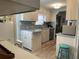 Bright kitchen featuring light-colored cabinetry, laminate floors, and a charming breakfast bar at 665 54Th S St # 133, Gulfport, FL 33707