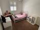 Bright bedroom featuring a charming white metal bed frame, and a window with white shutters at 6920 N Hubert Ave, Tampa, FL 33614