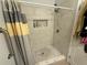 A white tiled shower stall with a marble floor and a built-in niche for toiletries at 6920 N Hubert Ave, Tampa, FL 33614