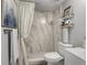 Updated bathroom featuring shower, marble-look tiling, floating shelves, and modern fixtures for a spa-like experience at 6923 Stones Throw N Cir # 4205, St Petersburg, FL 33710