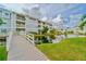 Exterior view of condos, showcasing balconies, a pond, and landscaping at 6923 Stones Throw N Cir # 4205, St Petersburg, FL 33710