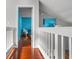 Upstairs hallway with hardwood floors, white railings, and brightly painted rooms, creating a cheerful atmosphere at 6923 Stones Throw N Cir # 4205, St Petersburg, FL 33710