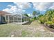 Backyard with screened-in pool, offering a peaceful retreat with ample space and landscaping at 6968 De Brita Rd, North Port, FL 34291