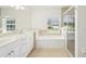Bathroom featuring a bathtub underneath a window, with a separate glass door shower at 6968 De Brita Rd, North Port, FL 34291