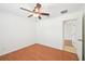 This bedroom has wood flooring, a ceiling fan, fresh paint, and an attached room at 6968 De Brita Rd, North Port, FL 34291