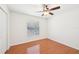 This bedroom has wood flooring, a ceiling fan, a window with blinds, and is freshly painted at 6968 De Brita Rd, North Port, FL 34291