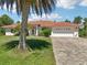 Single Gathering home featuring a terracotta tile roof, a two-car garage, and a meticulously landscaped front yard at 6968 De Brita Rd, North Port, FL 34291