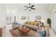 Spacious living room with neutral color palette, ceiling fan, tiled floors, and plenty of natural light at 6968 De Brita Rd, North Port, FL 34291
