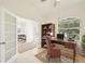 Bright home office features a wood desk, neutral walls, tiled flooring, and natural light from the large window at 6968 De Brita Rd, North Port, FL 34291