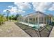 An enclosed swimming pool and deck with a single-story home beyond provide an ideal outdoor living space at 6968 De Brita Rd, North Port, FL 34291