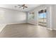 Bright room with ceiling fan, view of the lake from the sliding door, and modern plank flooring at 7140 Maysville Ct, Wesley Chapel, FL 33545