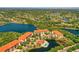 Aerial view of a lakeside condo community with a pool, showcasing its beautiful setting at 7710 Lake Vista Ct # 205, Lakewood Ranch, FL 34202
