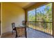 Enjoy scenic views from this screened balcony with tile flooring and a charming seating area at 7710 Lake Vista Ct # 205, Lakewood Ranch, FL 34202
