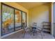 The tiled balcony has outdoor furniture and is a great place to relax with a view of the bedroom at 7710 Lake Vista Ct # 205, Lakewood Ranch, FL 34202