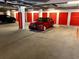 Secured parking garage with assigned spaces and red storage units at 7710 Lake Vista Ct # 205, Lakewood Ranch, FL 34202