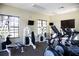 Well-equipped gym with various exercise machines and natural light from large windows at 7710 Lake Vista Ct # 205, Lakewood Ranch, FL 34202