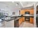 Kitchen featuring stainless appliances, granite counter tops, wood cabinets, and breakfast bar at 7710 Lake Vista Ct # 205, Lakewood Ranch, FL 34202