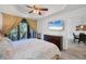 Bright main bedroom featuring a ceiling fan, private balcony, and flat screen television on the wall at 7710 Lake Vista Ct # 205, Lakewood Ranch, FL 34202