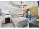 Bedroom with bed, lamps, and curtains with access to balcony at 7710 Lake Vista Ct # 205, Lakewood Ranch, FL 34202