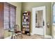 Well-lit home office offers a tranquil workspace with a bookshelf and a cozy chair with side table at 7710 Lake Vista Ct # 205, Lakewood Ranch, FL 34202