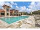Community pool with lounge chairs, shaded seating areas, and a well-maintained deck for relaxing at 7710 Lake Vista Ct # 205, Lakewood Ranch, FL 34202