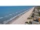 Breathtaking aerial view of the pristine beach with gentle waves meeting the shore and beachfront homes nearby at 1101 Bay Pine Blvd, Indian Rocks Beach, FL 33785