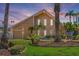 An inviting two-story home showcasing meticulous landscaping, mature palms, and a serene twilight ambiance at 1101 Bay Pine Blvd, Indian Rocks Beach, FL 33785
