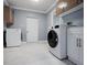 Spacious laundry room with a washer, dryer, storage cabinets, and tiled flooring at 1101 Bay Pine Blvd, Indian Rocks Beach, FL 33785