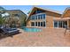 Beautiful backyard with a sparkling pool, brick patio and modern home design with waterfront views at 1101 Bay Pine Blvd, Indian Rocks Beach, FL 33785