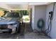 Carport showcasing a silver BMW and an electric car charger with a neatly coiled garden hose at 11233 51St N Ave, St Petersburg, FL 33708
