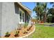 A side view of the home with a landscaped flower bed at 11233 51St N Ave, St Petersburg, FL 33708