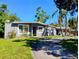 Inviting single-Gathering home with a well-kept lawn, curved driveway, and mature tropical landscaping at 11233 51St N Ave, St Petersburg, FL 33708