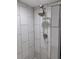 Modern shower with white tiled walls and a sleek showerhead. Features mosaic tile flooring at 11233 51St N Ave, St Petersburg, FL 33708