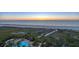 Tranquil ocean sunset viewed from above with palm trees, pool, and direct beach access at 1180 Gulf Blvd # 1201, Clearwater, FL 33767